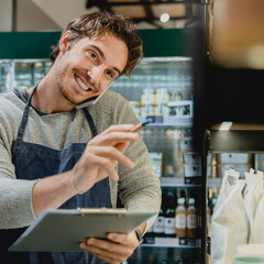 Cropped portrait of young handsome bartender shop assistant owner barman waiter barista talking on...