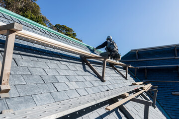 屋根を修繕する作業員