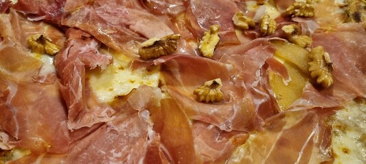 High-resolution image showcasing the toppings on a savory prosciutto and walnut pizza