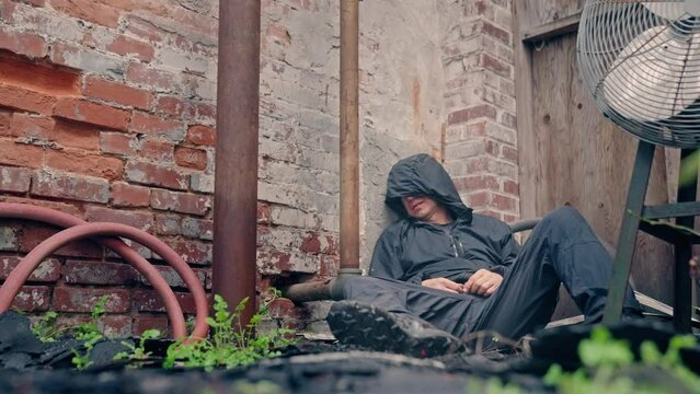 Man walking through abandoned building warehouse with frustrated anger rage. Homeless, depression, mental illness.