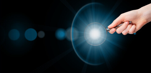 Magnifying glass in hand, light, insight. Banner background