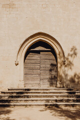L'extérieur de l'église en pierre et sa porte en bois