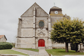 église en pierre entourée d'un jardin - obrazy, fototapety, plakaty