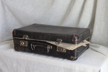 vintage black suitcase on a white background. Aura of travel history and nostalgia. Antique items