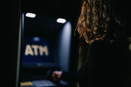 Girl Using ATM On The Street.