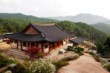A traditional Korean style building. A wooden Buddhist building with a tiled roof decorated with carvings. A Buddhist temple in Korea. South Korea.