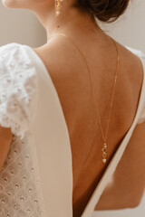 Le dos de la mariée habillé de fine dentelle et de bijoux