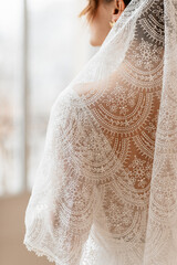 Mariée dans sa robe blanche portant son voile brodé - 773387256
