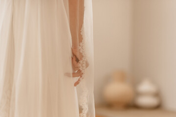 Mariée dans sa robe blanche recouverte par son voile - 773387295