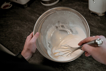 Preparing cake filling by whisking in a mixing bowl