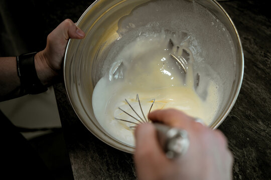 Preparing cake filling by whisking in a mixing bowl