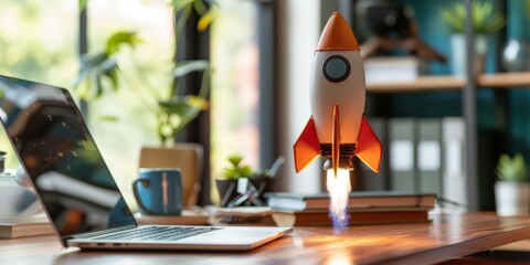 Rocket coming out of laptop on office table, startup concept