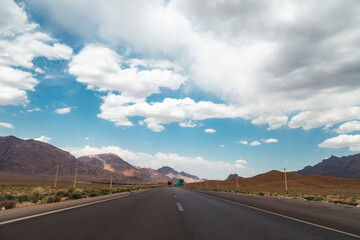 Road in the desert with blue sky and white clouds, background indicating the concept of travelling...