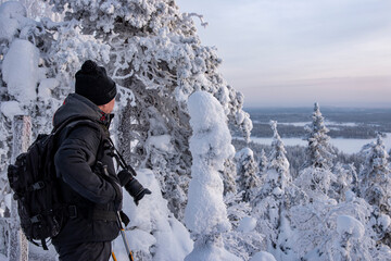 Fototapeta na wymiar Photographer in snowy forest