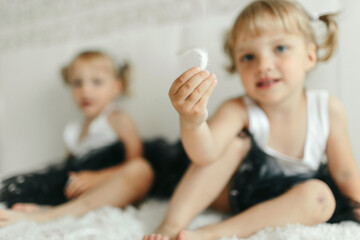 Little Girl Sitting on Bed Holding White Object