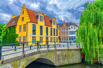 Old houses on embankment of Lieve water canal, trees on bank, Lievebrug bridge in Ghent historical city centre Prinsenhof Princes Court quarter district, Gent old town, Flemish Region, Belgium