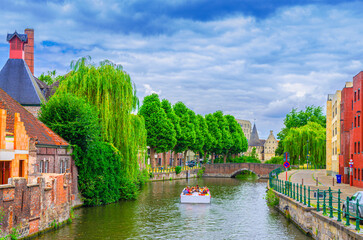 Ghent cityscape, brick buildings and trees plants on bank of Lieve water canal, embankment and Sint-Antoniusbrug bridge in Ghent city centre Prinsenhof Princes Court district, Gent old town, Belgium