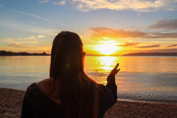 Silhouette of woman enjoying romantic sunset at beach in town Makarska, Split-Dalmatia, Croatia,...
