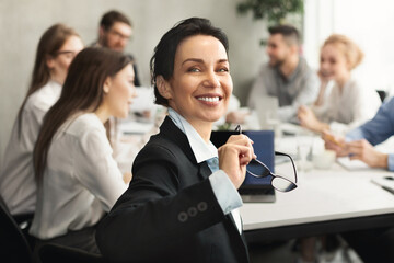 Professional woman leading a meeting in modern office - 773406211