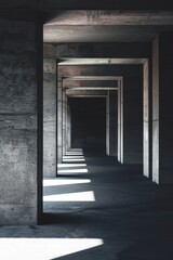 A series of concrete pillars stretches far into the distance in a dimly lit room, creating a sense of depth and geometry