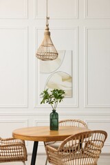 Dining room interior with comfortable furniture and green branches