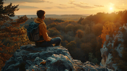asian hiker enjoying sunset on mountain rock.