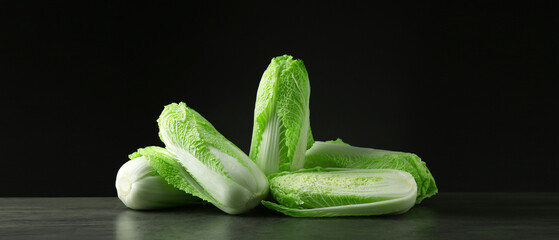 Fresh ripe Chinese cabbages on grey table against black background, banner design