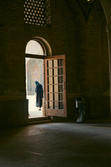 Muslim woman standing in front of a door in the old mosque in Shiraz, Iran.