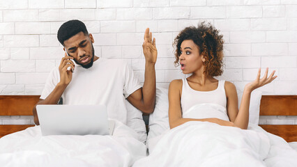 Couple in bed with woman exasperated at home