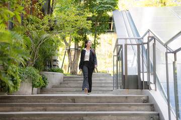 Confident businesswoman walking downstairs outdoors