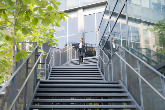 Confident businesswoman descending outdoor stairs