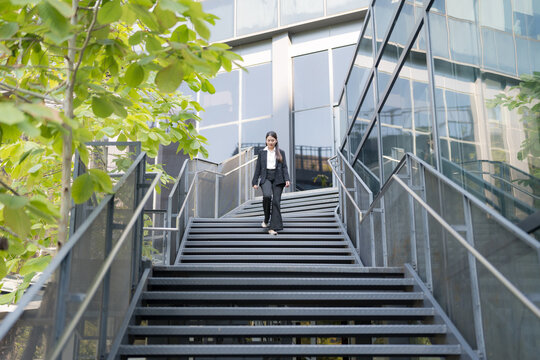 Confident businesswoman descending outdoor stairs