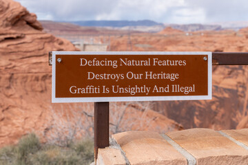 Sign at the Glen Canyon Dam overlook - Defacing Natural Features Destroys Heritage and Graffiti is...