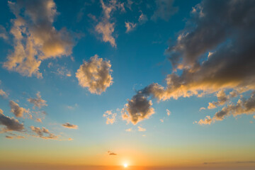 Sunset sky with bright colorful orange and yellow clouds. Panoramic skyscape