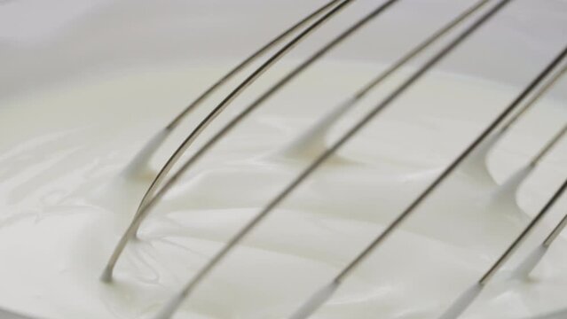 White creamy sauce texture close-up. Dipping and whisking by corolla a white yogurt macro. Dairy products concept. 