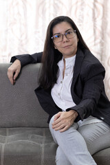 Retrato de joven mujer con lentes latina emprendedora, trabajando desde casa feliz