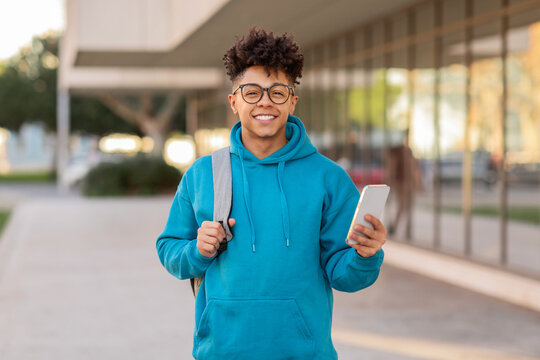 Young person holding phone and smiling