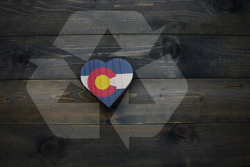 wooden heart with national flag of colorado state near reduce, reuse and recycle sing on the wooden...