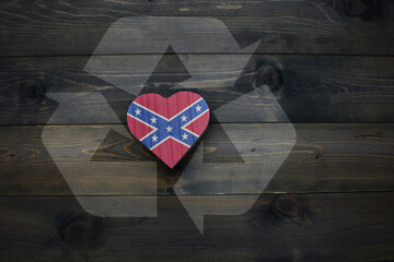 wooden heart with confederate flag near reduce, reuse and recycle sing on the wooden background....