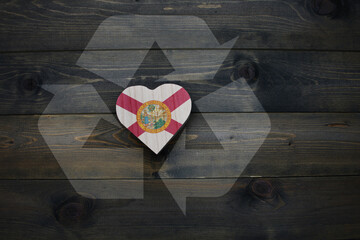 wooden heart with national flag of florida state near reduce, reuse and recycle sing on the wooden...