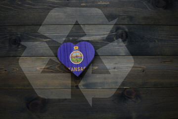 wooden heart with national flag of kansas state near reduce, reuse and recycle sing on the wooden...