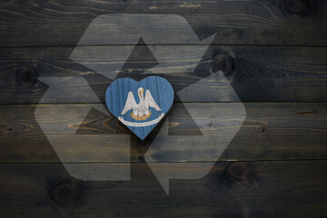 wooden heart with national flag of louisiana state near reduce, reuse and recycle sing on the...