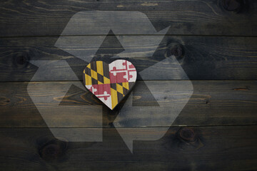 wooden heart with national flag of maryland state near reduce, reuse and recycle sing on the wooden...