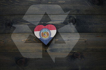 wooden heart with national flag of missouri state near reduce, reuse and recycle sing on the wooden...