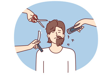 Hands with scissors and shaving devices around man with partially trimmed beard. Half-shaven guy is embarrassed about not wanting haircut or badly chosen barbershop