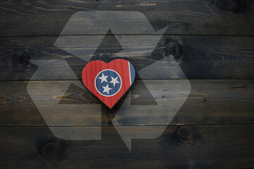 wooden heart with national flag of tennessee state near reduce, reuse and recycle sing on the...