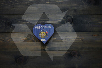 wooden heart with national flag of wisconsin state near reduce, reuse and recycle sing on the...