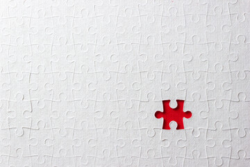 Missing piece in the puzzle on red background. Сoncept of finding a business solution. Selective...