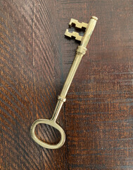 Old metal key. Antique golden key on a wooden background.