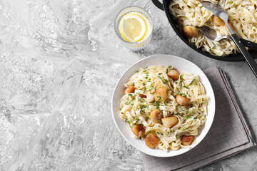 Delicious scallop pasta with spices served on gray textured table, flat lay. Space for text